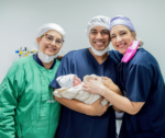 Obstetric doctor and midwives holding a newborn baby, providing pregnancy and childbirth care, with NDIS involvement only when complications result in long-term disability.