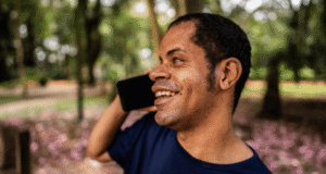 A First Nations man with vision impairment talks on a mobile phone.