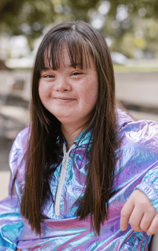 Annual Reports: Young woman with down syndrome wears a metallic jacket