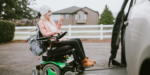 Young woman in a motorised wheelchair entering a minivan via side entrance ramp, demonstrating accessible transport through NDIS vehicle modifications