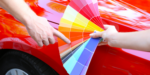 Customer choosing paint colour with red car in background, illustrating that NDIS vehicle modifications do not fund paint jobs, wraps or decals.