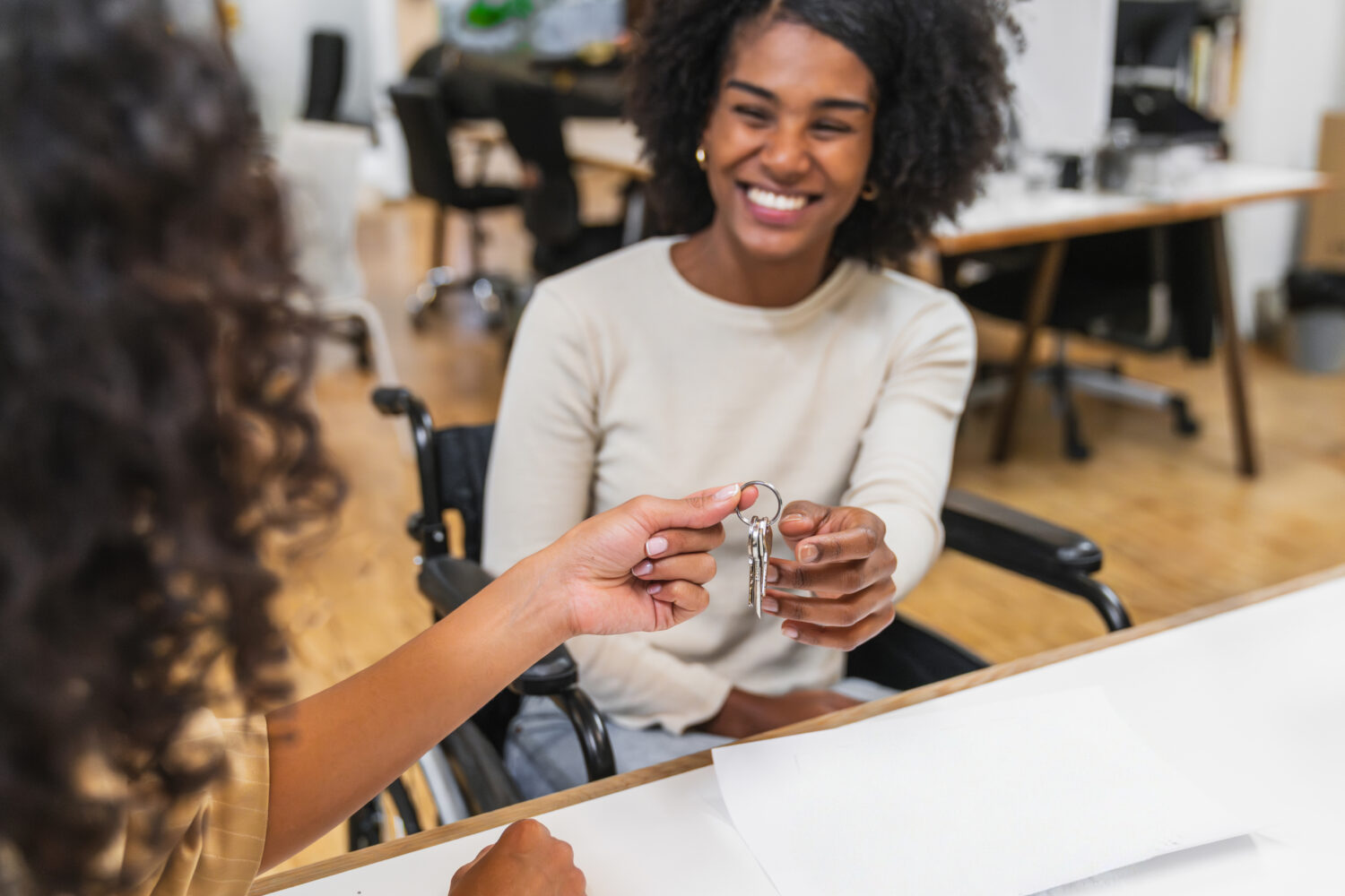 Woman in a wheelchair receives a Master Locksmiths Access Key MLAK disability access key to support access to accessible public facilities.