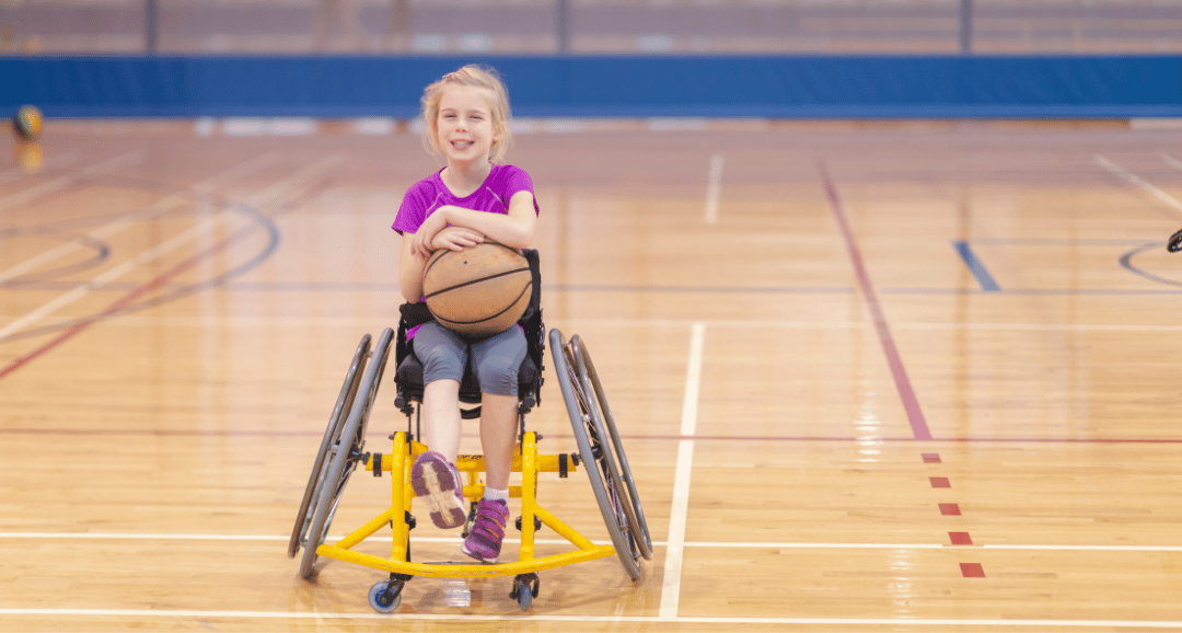 Assistive technology: A young girl playing basketball in her wheelchair, showcasing inclusive sports equipment.