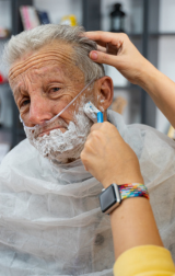 NDIS personal Care: Man receives help shaving by support worker.